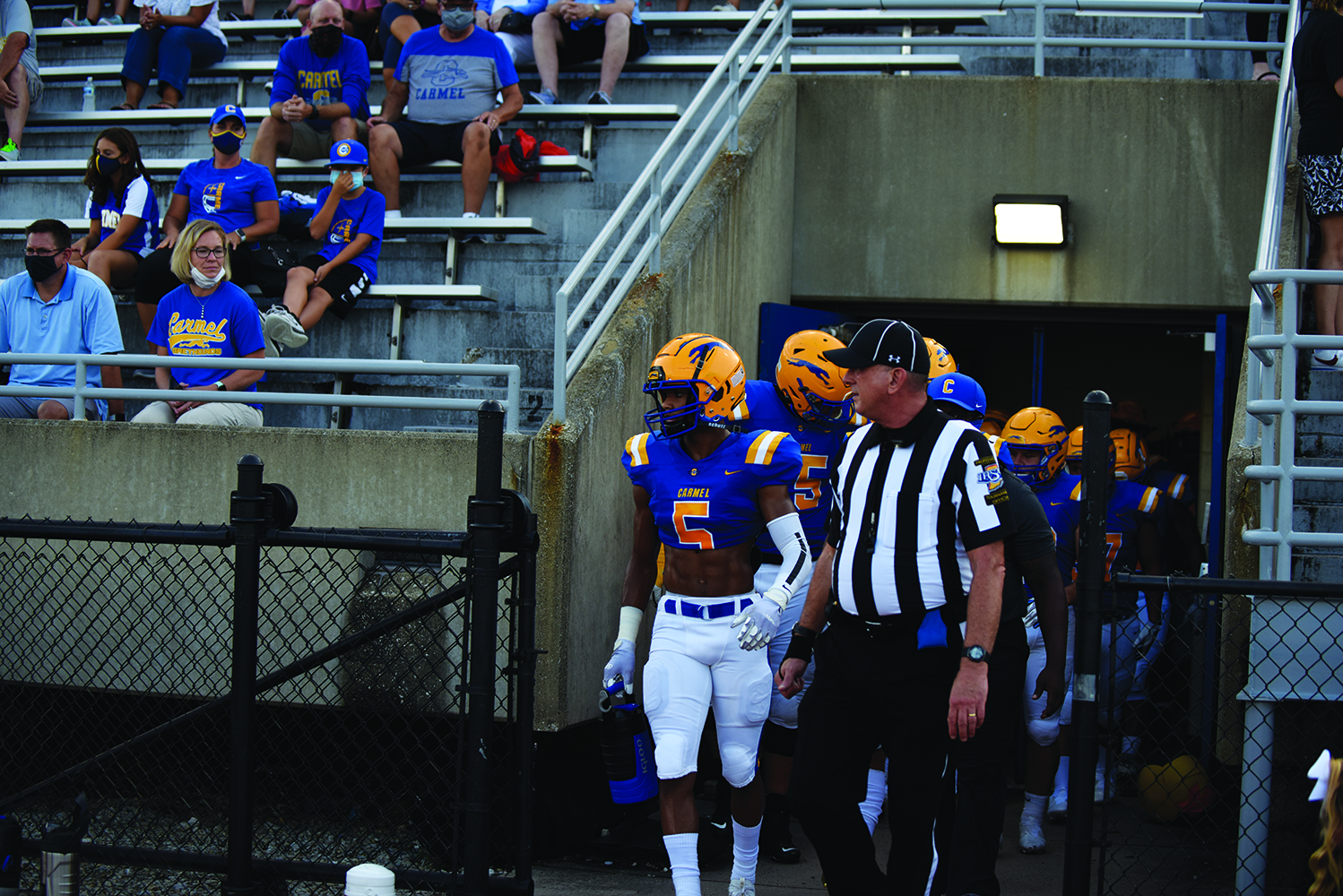 ROLE MODEL: Baron Smith, varsity football player and senior, leads his team out of the locker rooms. Smith said he takes the respondsibility of being a leader and reminding his team to stay distant. Smith said he wears a mask whenever he can to set an example and to lessen the spread of a possible case so that many players can get out on the field.
