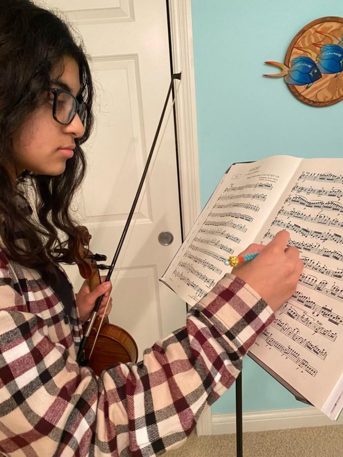 Junior Varsha Chandramouli practices her violin for symphony orchestra. At the time, Chandramouli no longer had evening rehearsals, and so she said she tried to practice more to compensate.
