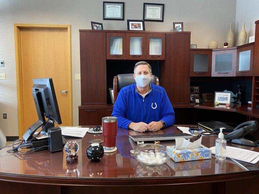 Principal Tom Harmas wears his mask to comply with COVID-19 guidelines while sitting at his desk. He said that administration is redeveloping the school’s Response to Intervention model to best meet student needs during the pandemic.