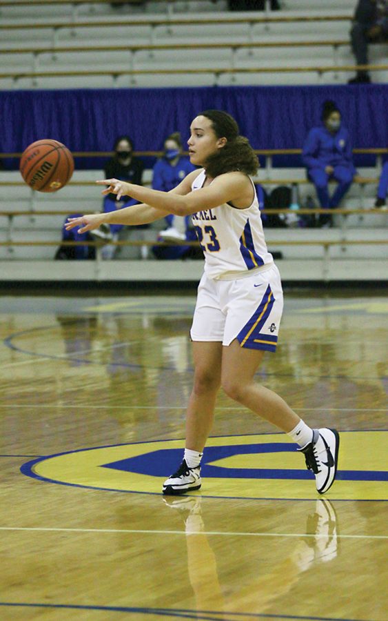 Riley Pennington, member of the women’s basketball team and senior, passes a basketball to a teammate during a game. She said she thinks the demographics of Carmel explain why there may be underrepresentation of blacks in some sports at CHS.