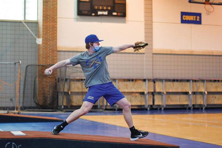 PITCH PERFECT:  
Daniel Cunningham, varsity baseball player and junior, practices pitching indoors. Cunningham said practices have been more difficult during the pandemic due to more baseball fields and training facilities being closed.