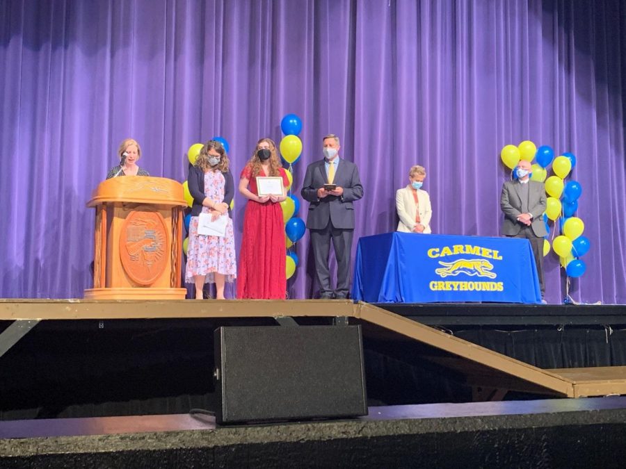 Principal Tom Harmas (third from right) holds a plaque for senior Sarah Konrad (fourth from right) at the Top Scholar Recognition Ceremony on April 19. Harmas said he is glad to have the opportunity to recognize seniors, even if these events have to be modified to accommodate COVID-19 guidelines.