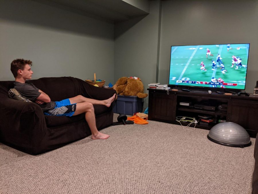 Sophomore Neil Fairman watches a NFL game between the Kansas City Chiefs and the Houston Texans on his TV. Fairman said he supports stadiums being filled to at least half capacity because it would improve the atmosphere at games. 
(NEIL FAIRMAN SUBMITTED PHOTO)