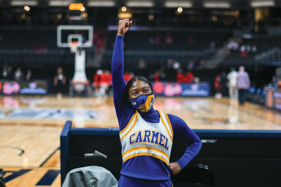 Trinity Griffin, varsity cheerleader and senior, cheers for the varsity basketball team at a home game in March. She said one of the biggest challenges to being a student athlete is trying to maintain grades at school while performing for a sport. Although she said she values her grades, she said she prioritizes her mental health over her school work and grades.