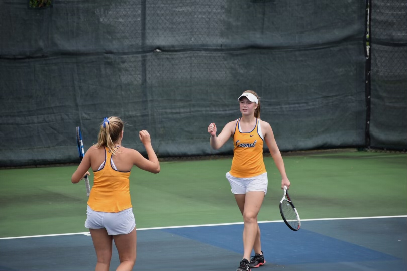 FIST BUMP: Senior Leila Antony (right) celebrates with one of her teammates during a tennis match. Antony and several others from Carmel qualified for the national tennis tournament run by the USTA (United States Tennis Association). She said working with a team has taught her how to build friendships and learn life skills.