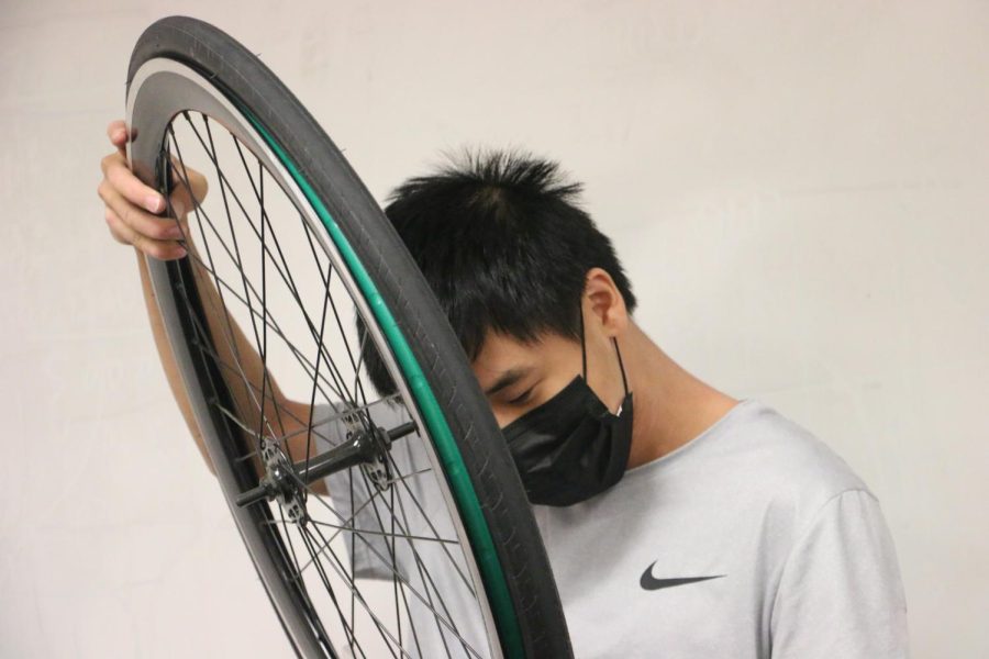 BREAK FOR BIKES: Sophomore Oliver Zhu works on a bike tire at the Carmel Cycling Club meeting on Oct. 7, 2021. Meetings are held regularly every other Monday in E206, however, this week the date was moved to a Thursday. At the meeting, Zhu demonstrated how to fix a flat tire and other aspects of bike repair.