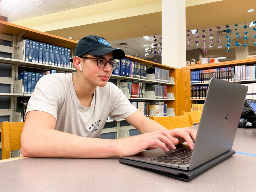 TEST PREP: Junior Noah Meroueh studies for his upcoming AP Statistics test in the library on Feb. 22. Meroueh was using videos, slideshows, and practice worksheets to prepare for the exam.