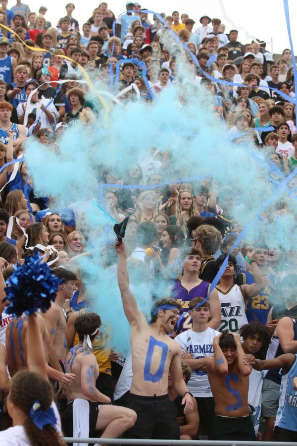 Senior Trevor Tilev releases blue smoke into the crowd during the beginning of the second home game of the season on Sept. 3. Tilev led the crowd in cheering loudly for the men’s varsity football team. Carmel played Center Grove and lost 41-14. The Hounds will play North Central next at the Homecoming game tomorrow; the theme of the game is Blue and Gold. 