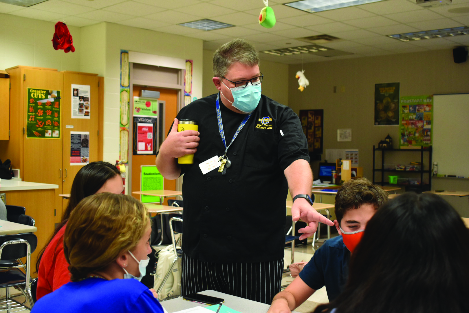 Culinary Arts teacher Nicholas Carter, wearing a traditional chef’s jacket, instructs his students on collaboration skills in the kitchen on Sept. 8. He said usually second year culinary students run the Carmel Arts Festival booth, providing them valuable cooking experience.
