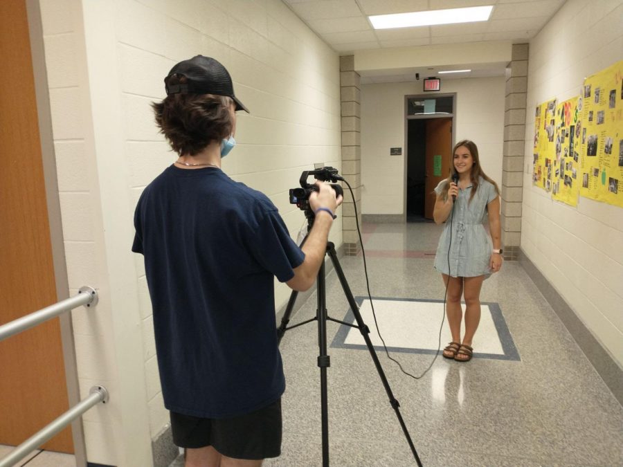 Anchor and senior Morgan Mace begins recording a video with senior Kayden Lyons. The video was a collection of student interviews on their favorite halloween traditions. 
