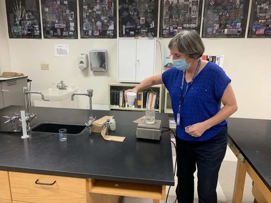 Chemistry Club sponsor Virginia Kundrat works on a lab setup in her classroom. Kundrat said club members will help lead chemistry demonstrations and participate in outreach for elementary and middle school students this year.