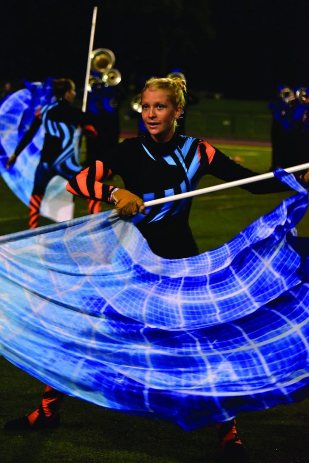 Sophomore Lorelai Sokol performs during halftime of the Carmel football game against Warren Central on Oct. 8. Sokol is a member of the Carmel Color Guard and is beginning the Winter Guard season in November. The color guard performs alongside the marching band at football games and competitions.