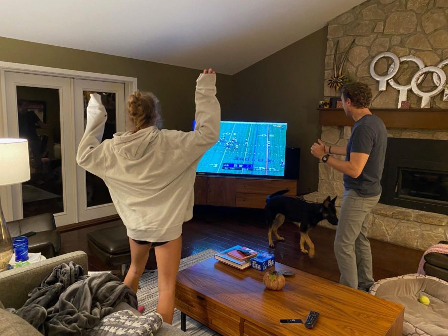 Sophomore Nora Perkins (left) celebrates as she watches a football game on TV with her dad.Perkins said she and her family are football fans who regularly watch IU games and the NFL.