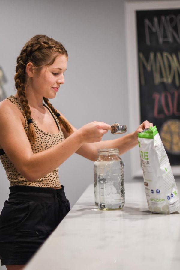 Junior Peyton Henney mixes protein powder into her water bottle post-workout in her kitchen. According to Henney, “My favorite ‘cheat’ snack is anything chocolate and my favorite healthy snack is frozen strawberries with vanilla Greek yogurt.”