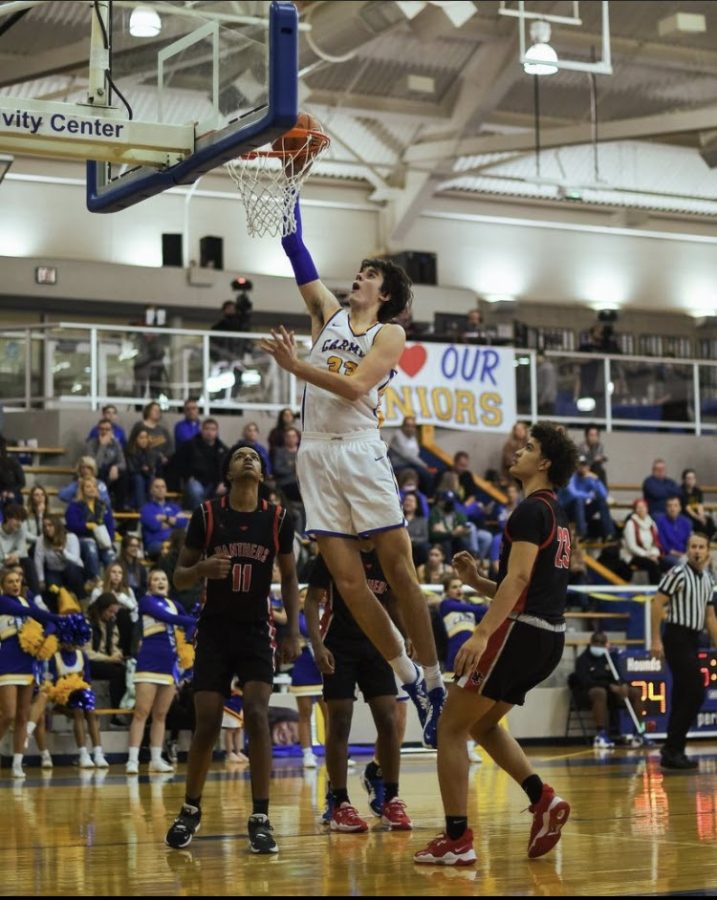 Charlie Williams, basketball player and senior, gets by the defense and dunks the ball for two points. Coach Conley said the team has a great chance to be a top contender for the State championship in early April. 
Photo Credits: Luke Miller