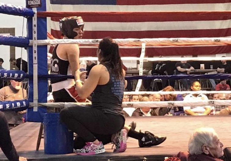 Boxing trainer Suzana Rodriguez-Griffin (right) speaks to a boxer between rounds at a boxing match. Rodriguez-Griffin said she personally does not trash talk when boxing others, as to her, trash talk is besides the point of boxing. 