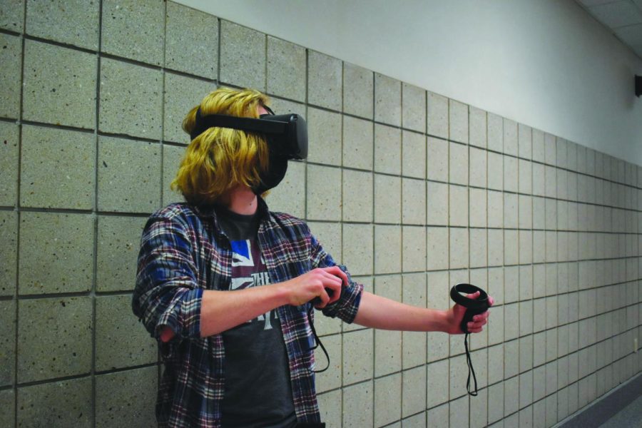 Using his headset and controllers, Harrison Carter, eSports member and junior, illustrates the capabilities of virtual reality (VR). Carter said the affordability of the Oculus Quest helped him learn about VR and he now uses it for games and to connect with friends.