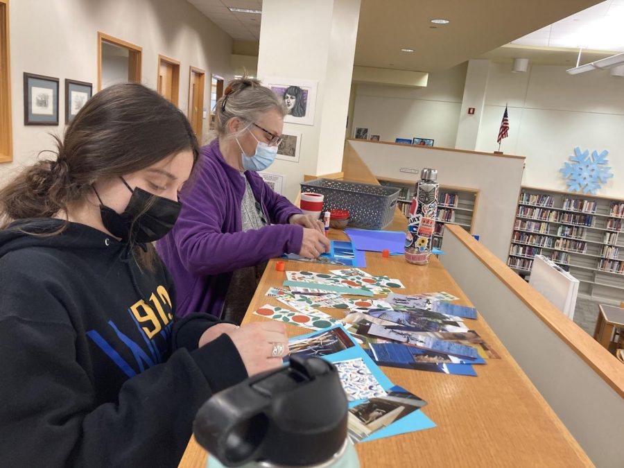 Media specialist Theresa Ramos creates bookmarks using paper and glue. Free, laminated bookmarks are available at either of the desks at the library entrances. 