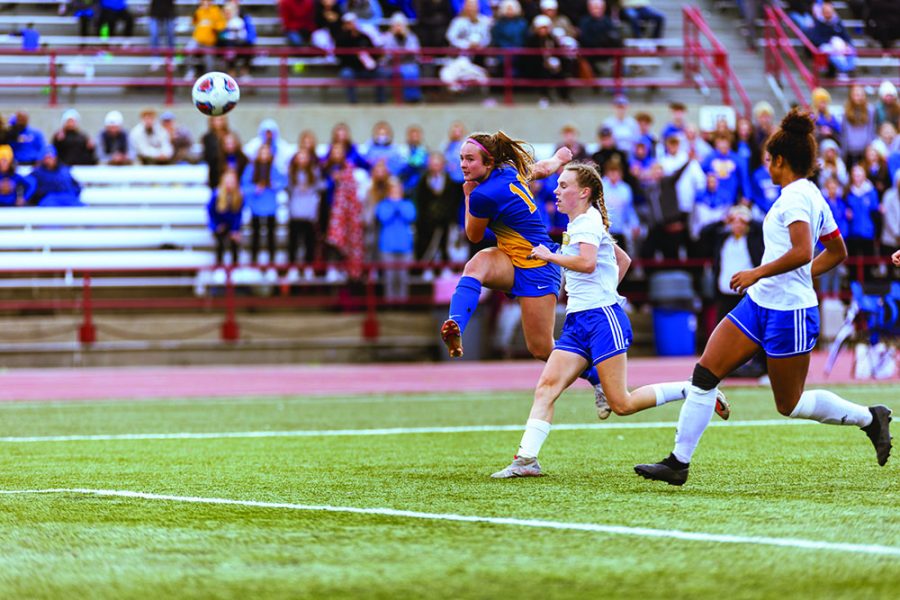 Sophie Shepherd, soccer player and junior, jumps for a header during a game. Shepherd said soccer is enjoyable for her because she can use her strengths more when playing.