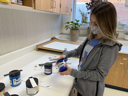 Painting teacher Anna Kramer closes the acrylic paint jars used in her painting class. She said, “Usually I start (the year) by teaching color theory because that’s huge with painting”
