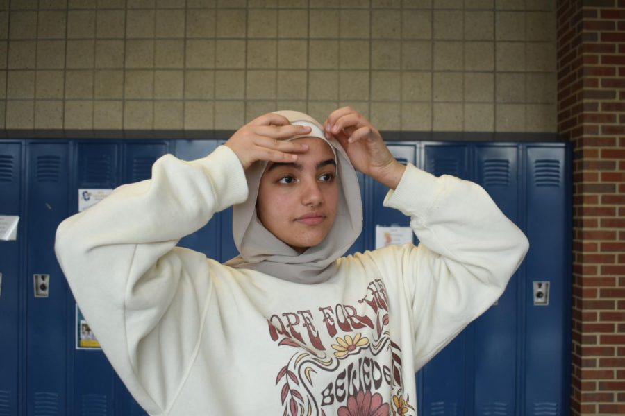 Freshman Mariam Morad fixes her hijab. Many women who practice Islam wear hijabs, but people choose to practice their religion in different ways.