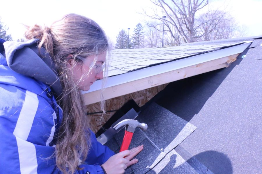 Senior Sophia Hanna nails a panel into the roof of the Tiny Home, which will have running water, electricity and gas when completed. 