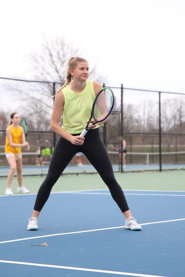 Lauren Littell, varsity tennis player and senior, prepares to return a serve during practice. Littell said she hopes to win both the State Championship as a team and individual this year.