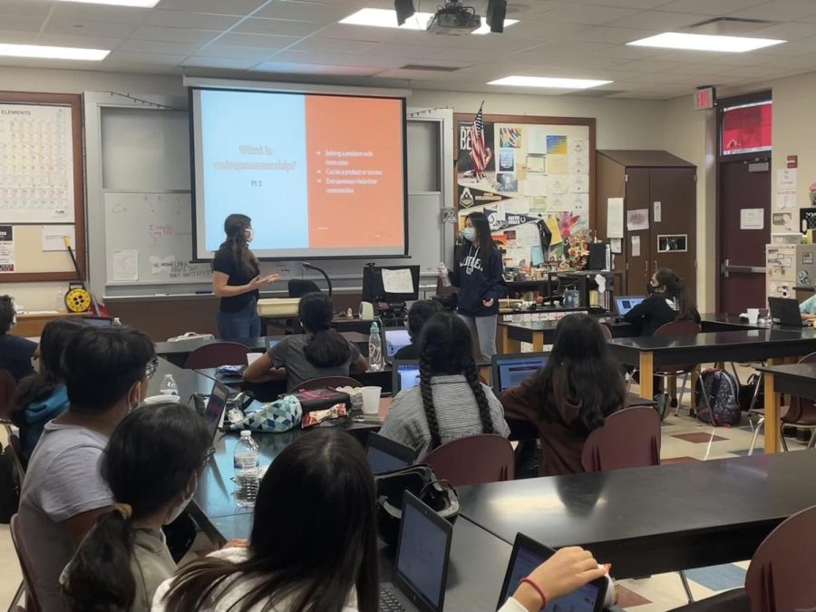 Seniors Claire Qu and Megan Shaffer teach business concepts to a group of middle schoolers. They said the winning groups project will implemented this week at Clay Middle School.