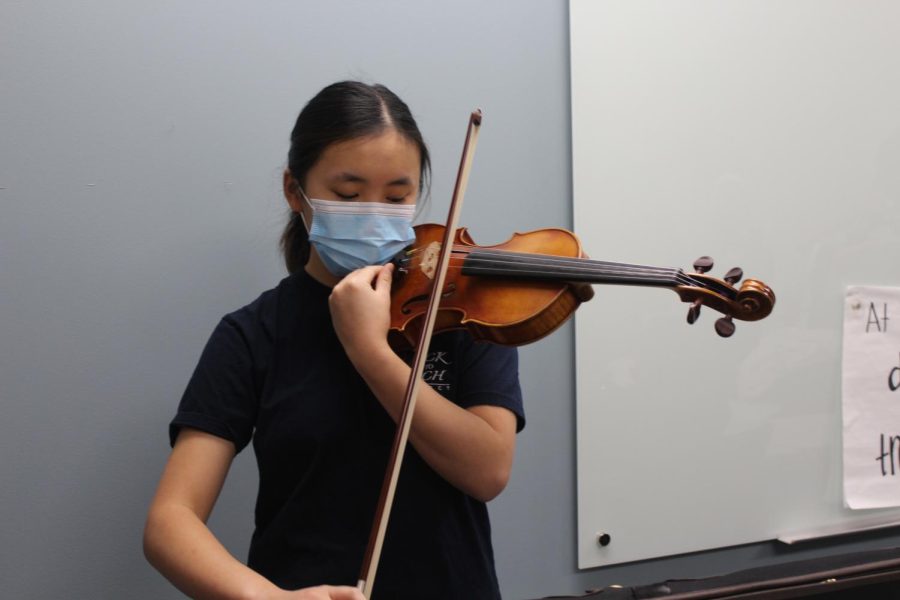 Caption: Freshman Hillary Yang tunes her violin for a performance on Feb 3rd, 2023. Students in the Back to Bach nonprofit organization travelled to Boone Meadow Elementary School to teach a group of fourth grade students about different string instruments. 