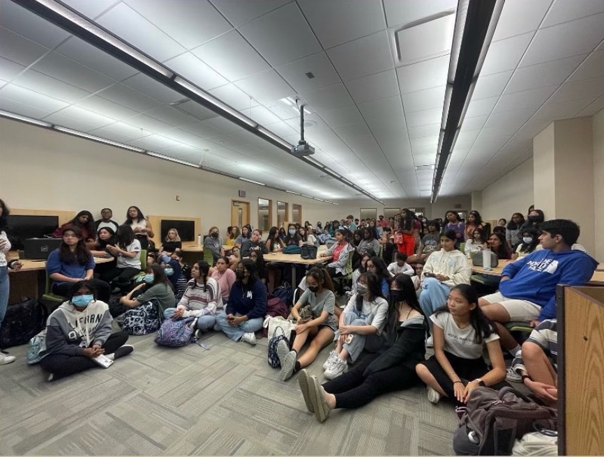 Junior Rebecca Lee (middle) sits on the ground in the library media rooms with other HOSA members at the callout meeting on Sept. 14. (Submitted Photo: @carmelhosa)