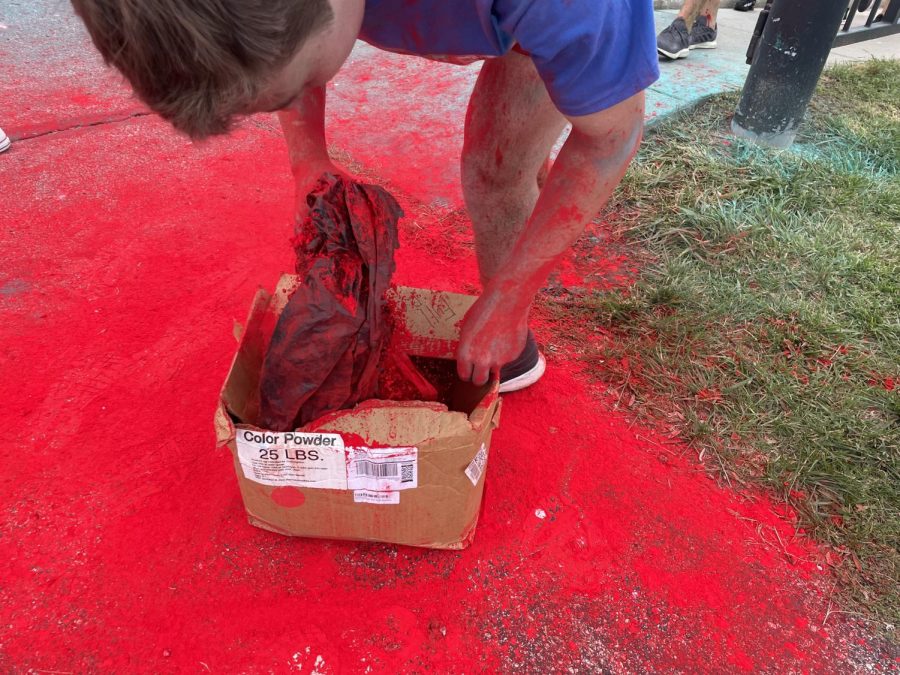 A Cabinet member throws powder on runners at the Race for Riley color run on Sept. 17. The Cabinet used boxes of powder like the one in the picture, as well as colorful, liquid paints. 