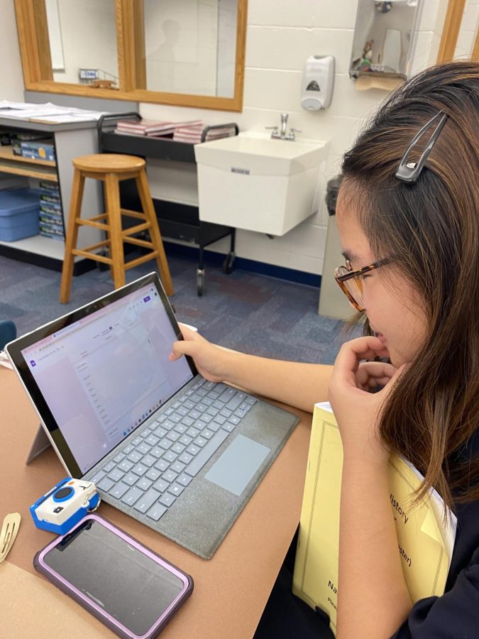 Grace Guo, photographer of A5 and junior, looks through the club roster for yearbook photos. Guo said that club member have risen to 180 members since last year.

