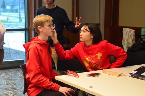 A volunteer at the Lunar New Year event on Monday’s paints a CHS student’s face. They wear red, which symbolizes the Lunar New Year in Chinese culture. 
