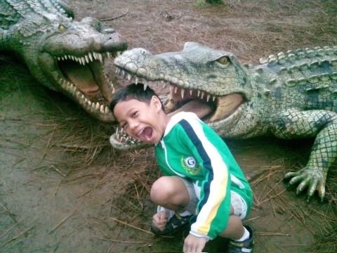 Sophomore Augustus Dagasuhan poses in front of alligator statues at the Dahilayan Adventure Park on the Philippine island of Mindanao in 2013. He said that due to the Philippines economy, the park is a great vacation spot.