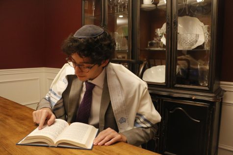 Senior Zachary Zach Mintz reads from a Siddur which contains different blessings said on a variety of occasions. It also contains some texts from the Torah which are read on a weekly basis.