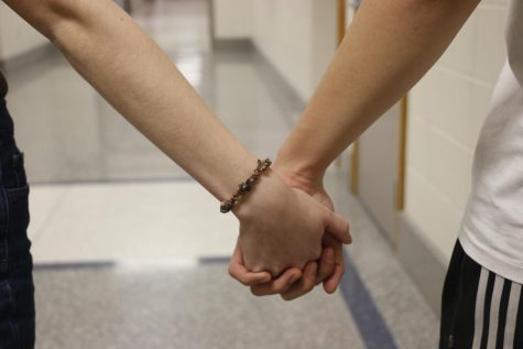 A couple holds hands in the CHS hallway. Junior Will Strines said that it is important to manage your own personal time along with your dating time well.