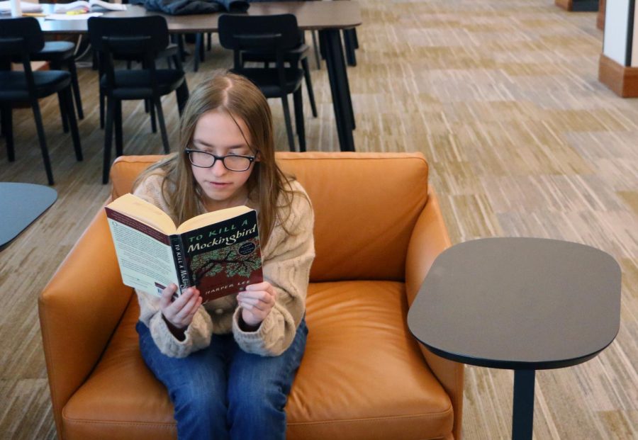 Senior Shannon Larkey reads the famous novel To Kill a Mockingbird, written by Harper Lee on Feb. 18 at the CCPL. This novel is in the curriculum for both Honors English 8 and English 9, but has faced issues in other districts because of the language used in the text.