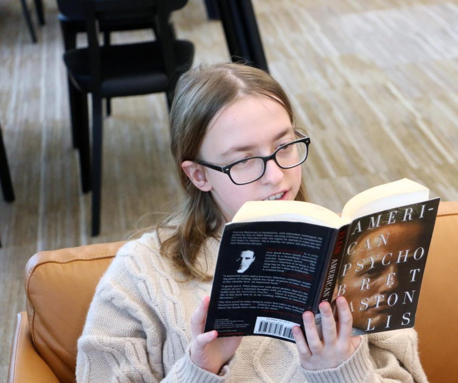 Senior Shannon Larkey reads American Psycho by Bret Easton Ellis at the ccpl the afternoon of Feb. 18. The novel is commonly banned due to the explicitly violent nature of the main character and the detailed descriptions of his actions, yet is still available at the CCPL.