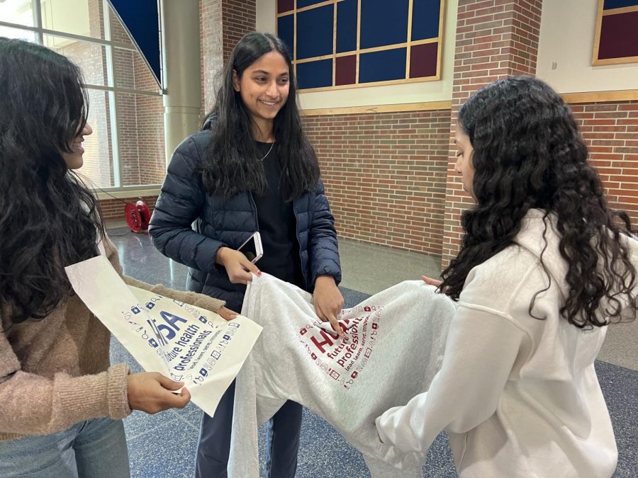 Amogha Paleru, competitions head and senior, holds Health Occupation Students of America (HOSA) merchandise during the club meeting in the Freshman Cafeteria on March 2. Paleru said members should be confident when delivering their presentations to the judges at SLC.