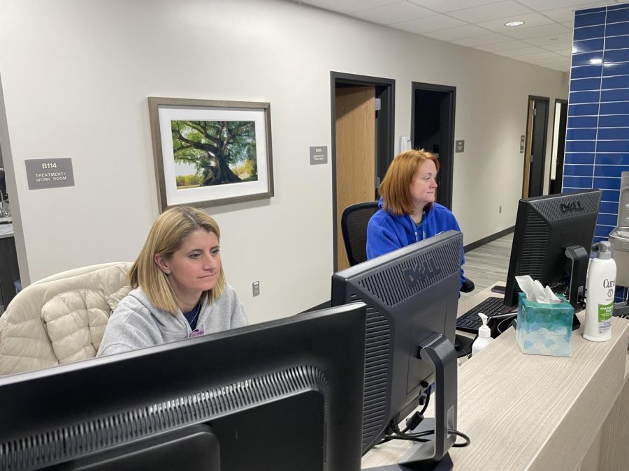 Registered Nurses Lori Justin (left) and Caroline Pasko (right) work on their computers while no students need their care. Registered Nurse Amy Fletchall said, “Our main goals are keeping the students and staff healthy while being mindful of the importance of not missing instructional time.”