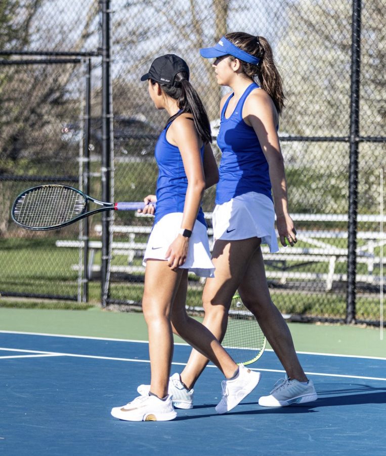 Varsity women’s tennis players discuss strategies and help motivate one another before competing. Senior and player Alexa Lewis said she helps to lead the team and bring them closer together.
