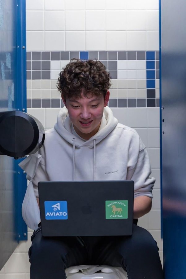 Sophomore Eric Zhu sits on a toilet with his laptop open. Zhu said that his company Aviato is a way for people to engage in venture capitalism anywhere, anytime. (Submitted photo: Eric Zhu)