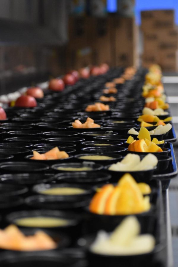 CHS cafeteria staff prepare fruit and vegetable cups for student lunches. The organic food waste from their production, like apple cores and orange peels, is now composted rather than thrown away with the funds of the composting grant.