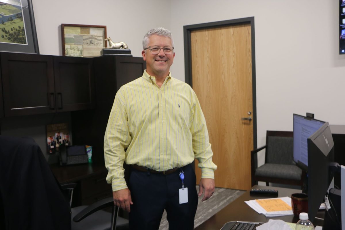 Principal Tim Phares stands at his desk. Phares said he hopes to be accessible and visible to students.

