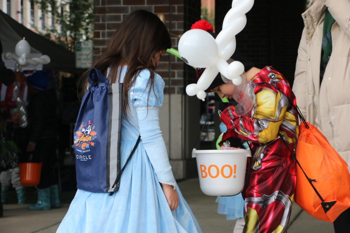 A kid dressed as Iron Man shares their candy with their friend dressed as Cinderella at The Arts in Autumn event at Midtown on Oct. 14. During the event, kids got to dress up and visit booths to trick or treat as well as many other fun activities. 