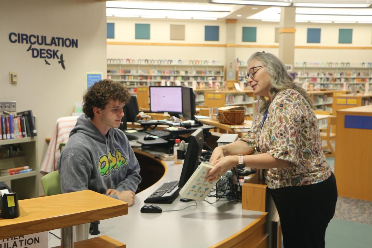 Media department chairperson Terri Ramos talks to a student about a book. Ramos said, “Books are such a powerful tool for communication and I think it’s important that the students understand that as well.”