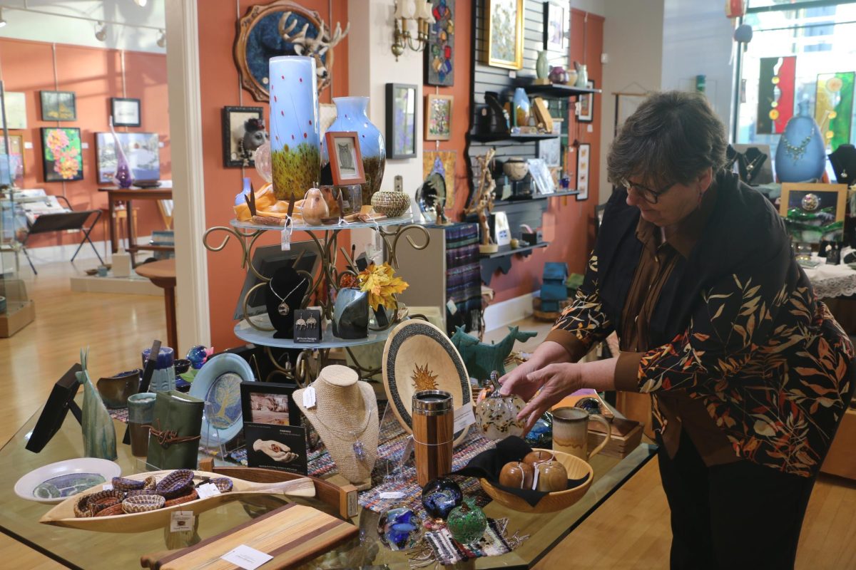 Ros Demaree, director of Indiana Artisan, arranges products in Indiana Artisan, a business participating in Shop Small, Shop Carmel. Demaree said, (Shop Small, Shop Carmel) is a good day for us to introduce ourselves to new people, to reconnect with people who have been here before.