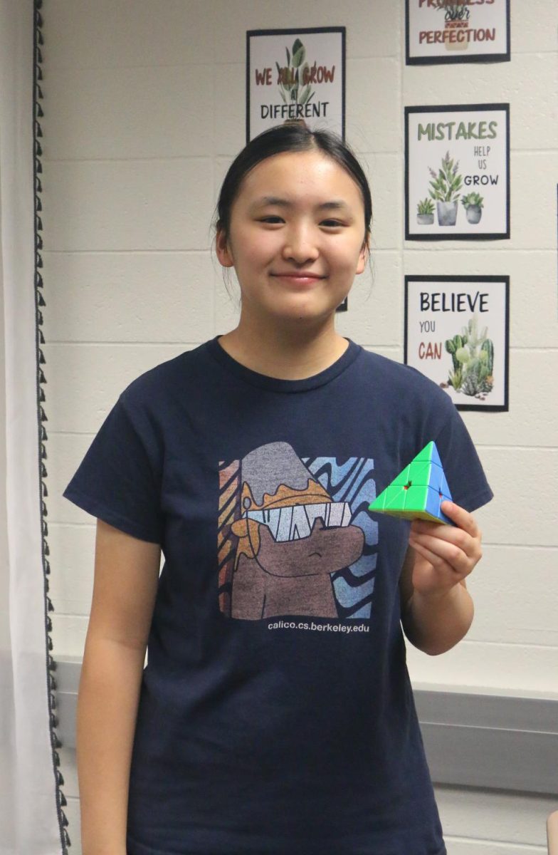 Sophomore Hillary Yang poses with the Pyraminx. Yang said her average time for the Pyraminx is 2.8 seconds, while her best is 1.8 seconds, the second best in the nation for females.