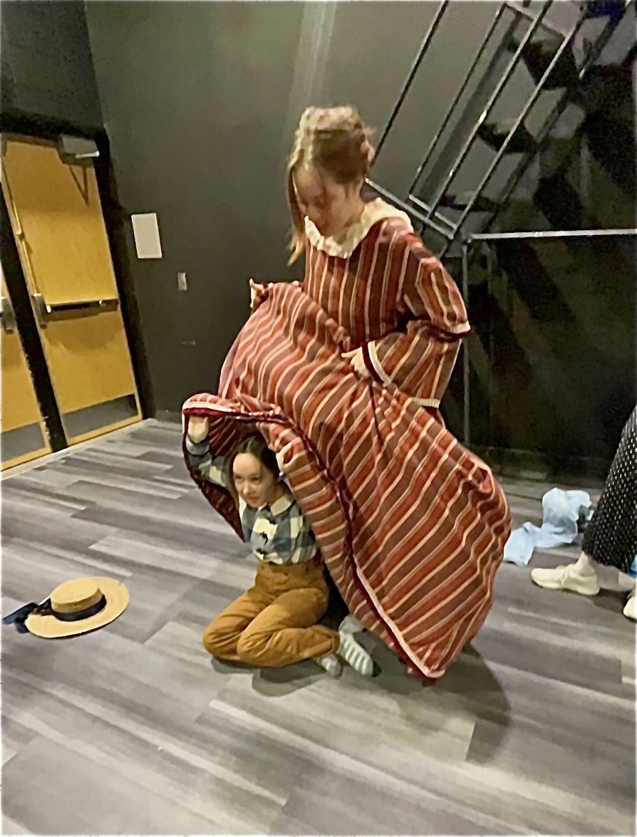 Seniors Juliet Malherbe and Eden Hammond try on costumes during “Little Women” rehearsal. The cast has begun developing their characters and focusing on building relationships in the show. “I think all of the actors do an amazing job pulling all of the characters together,” Sophia Scelzo said. “I love seeing all the nuances of girlhood and family starting to show during rehearsals.”