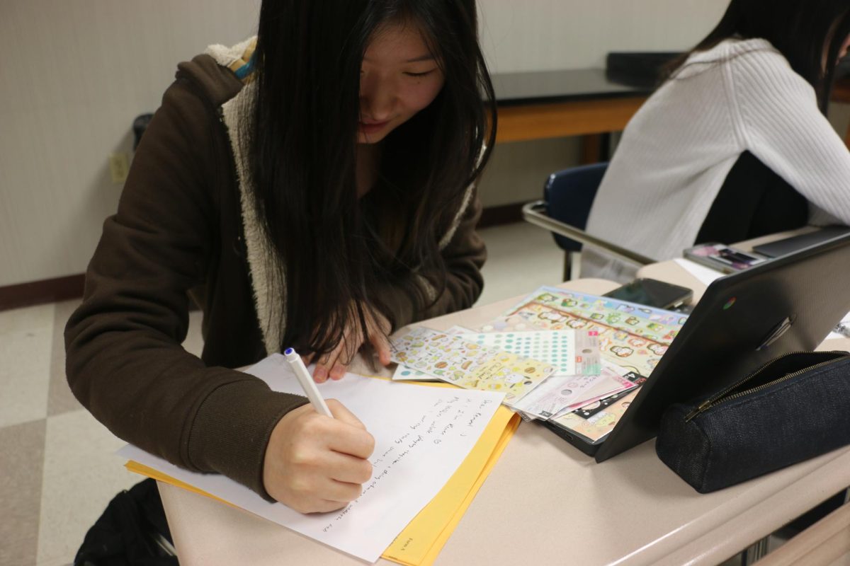 Senior Renee Kim writes a letter to her penpal in Japan. “Writing letters is honestly my favorite part, especially because I love stickers and it’s so fun to go in and personalize it. That shows the person receiving it a bit of my personality,” Kim said.
